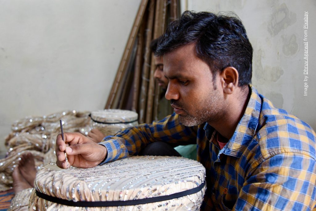 Artisan concentrating on the fabric he is embroidering