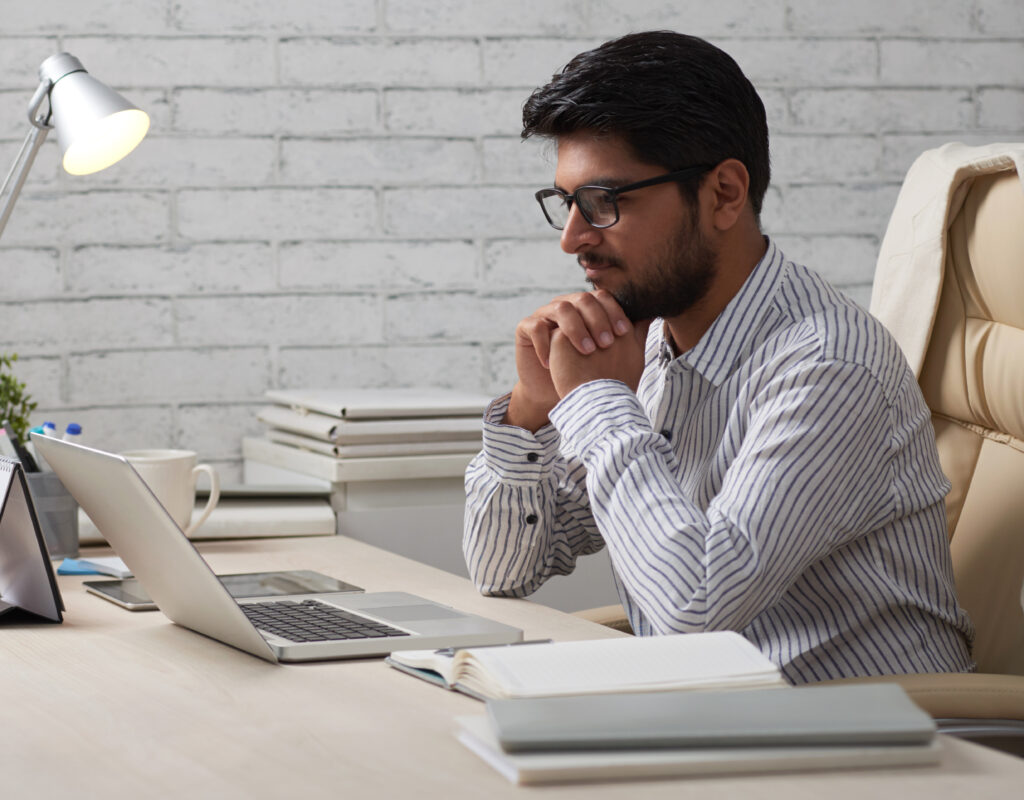 Man smiling while looking at a computer screen